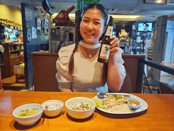 浅草寿町ランナータイレストランの定員さんがお料理のまでビール瓶を持つ